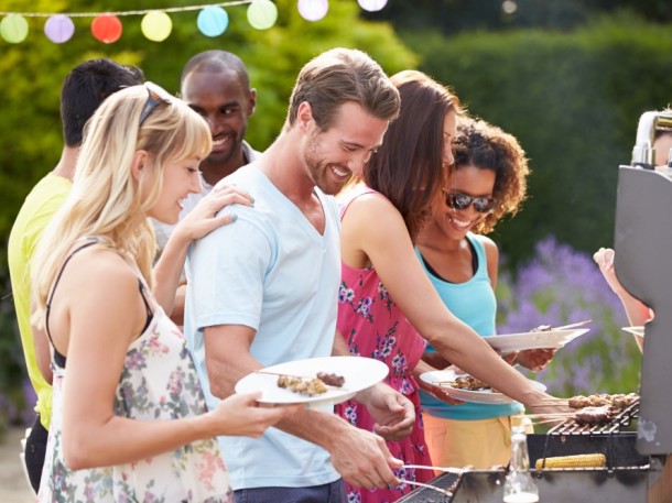 group of friends outside at bbq grill event eating